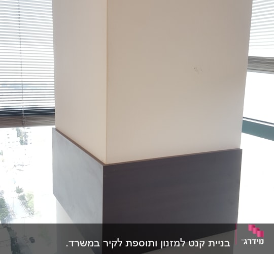 עמוד עם חיפוי עץ כהה במרכזו
